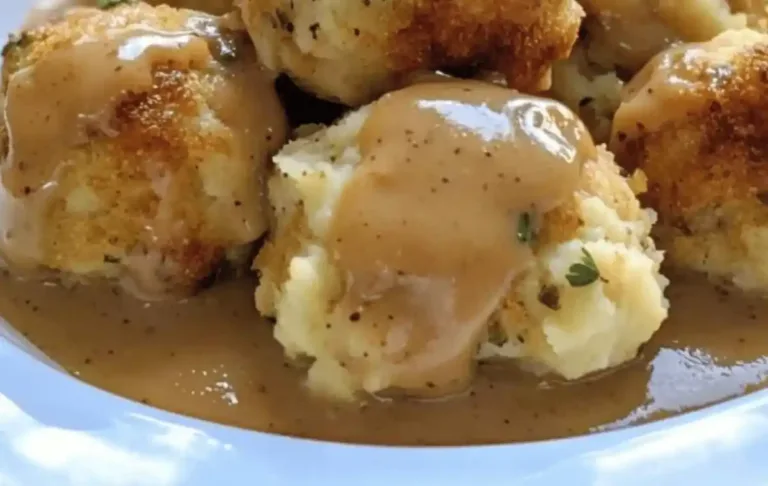 Golden baked turkey stuffing balls on parchment-lined baking sheet, crispy outside and fluffy inside.