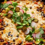 Black Bean Quinoa Enchilada Bake dish garnished with fresh cilantro and avocado.