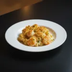 Delicious shrimp casserole ready to serve with golden topping and garnished herbs